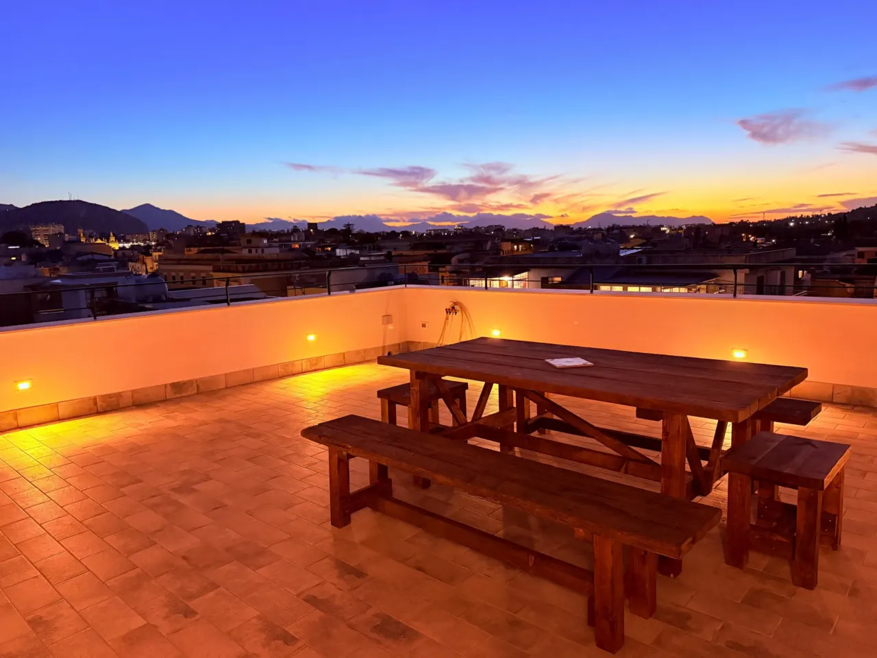 Terrasse in der Abenddämmerung mit Tisch und Bänken